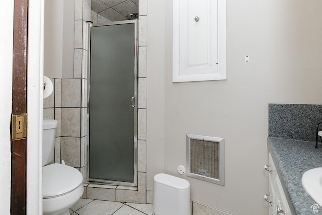 3704 S State St, Preston, ID 83263 - bathroom featuring toilet, vanity, a stall shower, tile patterned flooring, and tile walls