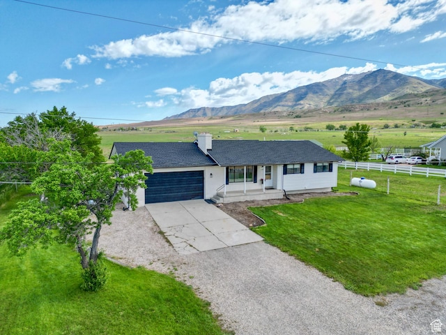 1491 Bryan Rd, Erda, UT 84074 - ranch-style house featuring concrete driveway, an attached garage, covered porch, a mountain view, and a view of rural / pastoral area