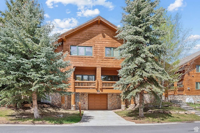3975 Timberwolf Ln Unit 2C, Park City, UT 84098 - view of front of property with stone siding, an attached garage, a balcony, and driveway