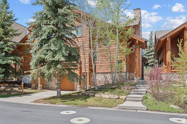 3975 Timberwolf Ln Unit 2C, Park City, UT 84098 - view of front of home with stone siding, concrete driveway, and a chimney