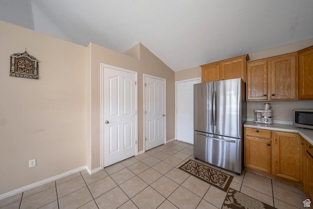 6216 S Waller Ln W, West Jordan, UT 84081 - kitchen featuring appliances with stainless steel finishes, light countertops, vaulted ceiling, light tile patterned floors, and brown cabinets