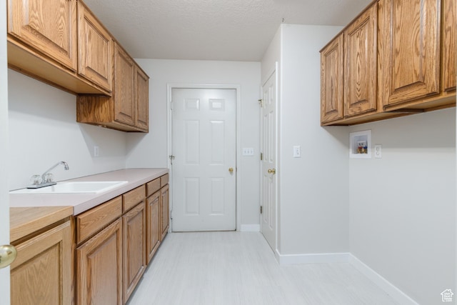 2275 W 1500 S Unit 28, Syracuse, UT 84075 - washroom featuring cabinet space, washer hookup, baseboards, light flooring, and a textured ceiling