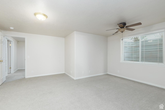 2275 W 1500 S Unit 28, Syracuse, UT 84075 - spare room featuring light carpet, a ceiling fan, baseboards, and a textured ceiling