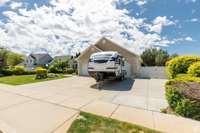 2275 W 1500 S Unit 28, Syracuse, UT 84075 - view of front of home with a gate, stone siding, concrete driveway, and a garage