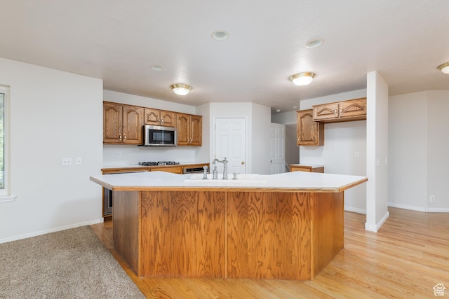 2275 W 1500 S Unit 28, Syracuse, UT 84075 - kitchen with stainless steel microwave, a sink, light countertops, baseboards, and brown cabinetry