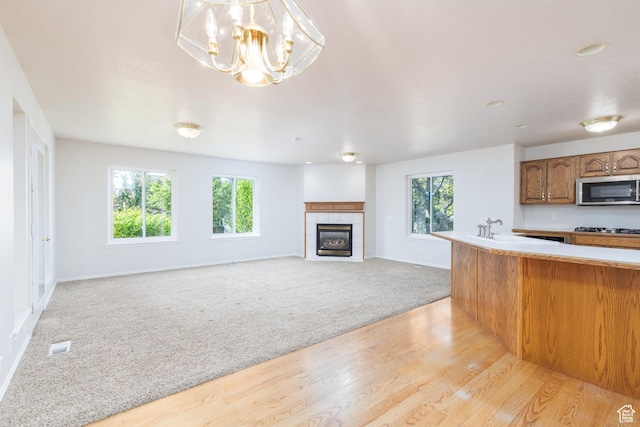 2275 W 1500 S Unit 28, Syracuse, UT 84075 - kitchen featuring stainless steel microwave, light colored carpet, a sink, light countertops, and light wood finished floors