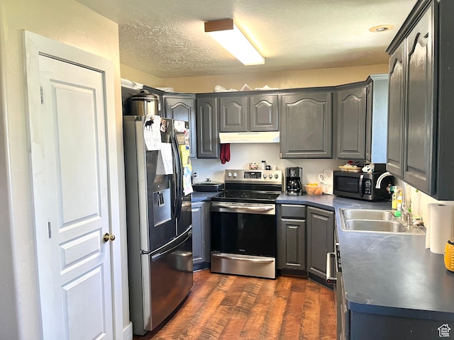 524 W 860 S, Tremonton, UT 84337 - kitchen featuring stainless steel appliances, under cabinet range hood, dark countertops, gray cabinetry, and a textured ceiling