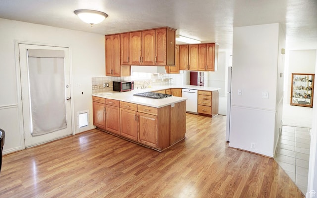398 S 900 E, Smithfield, UT 84335 - kitchen with stainless steel appliances, a peninsula, light wood-style flooring, light countertops, and tasteful backsplash