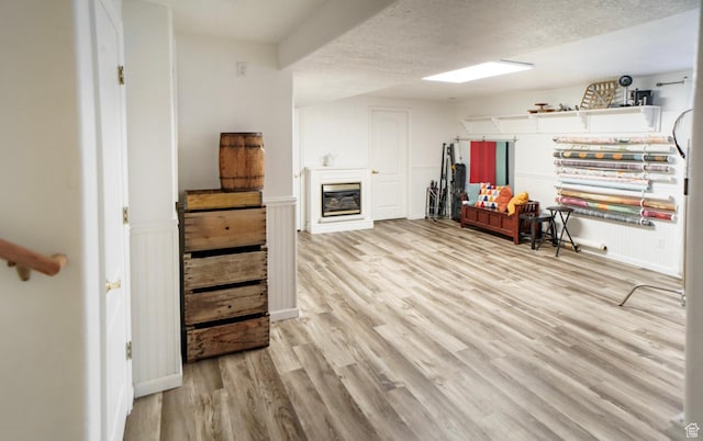 398 S 900 E, Smithfield, UT 84335 - below grade area featuring light wood finished floors, a glass covered fireplace, a textured ceiling, and wainscoting