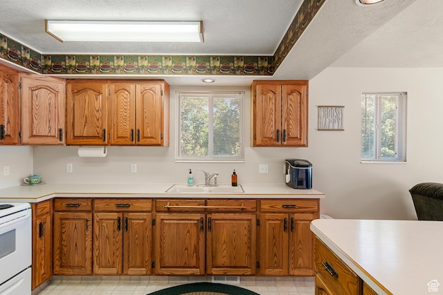 27 Lake W Cir, Fish Haven, ID 83287 - kitchen with a sink, white electric range oven, light countertops, and brown cabinetry