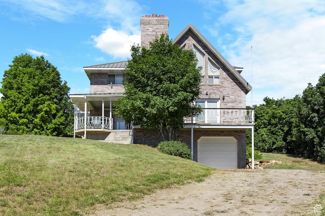 27 Lake W Cir, Fish Haven, ID 83287 - view of front facade with a standing seam roof, a chimney, driveway, a garage, and a front yard