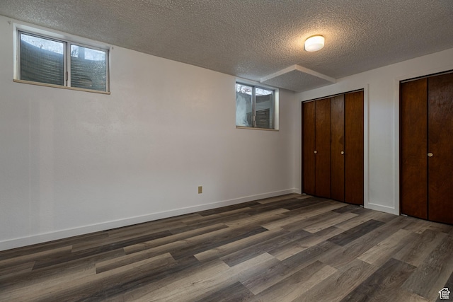 437 S 100 W, Kanab, UT 84741 - unfurnished bedroom with a textured ceiling, two closets, dark wood-style flooring, and baseboards