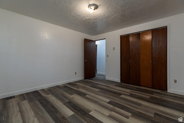 437 S 100 W, Kanab, UT 84741 - unfurnished bedroom featuring dark wood-style floors, baseboards, a closet, and a textured ceiling