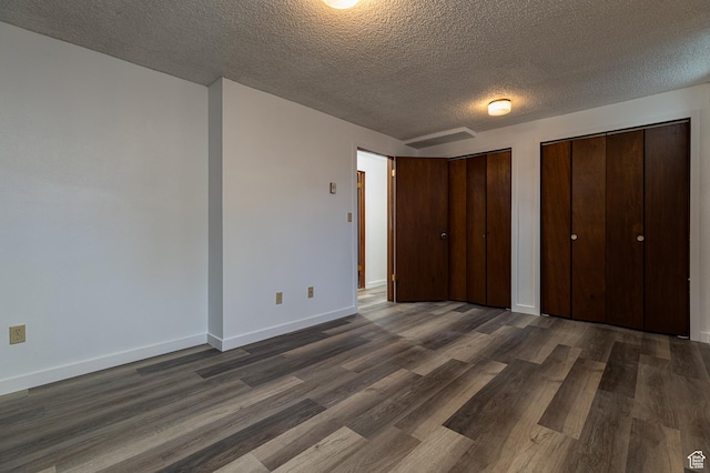 437 S 100 W, Kanab, UT 84741 - unfurnished bedroom featuring a textured ceiling, dark wood-style floors, multiple closets, and baseboards