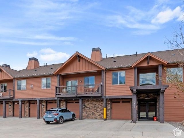 14311 N Buck Horn Trl Unit 42N, Kamas, UT 84036 - view of front of house with board and batten siding, a garage, stone siding, and a chimney