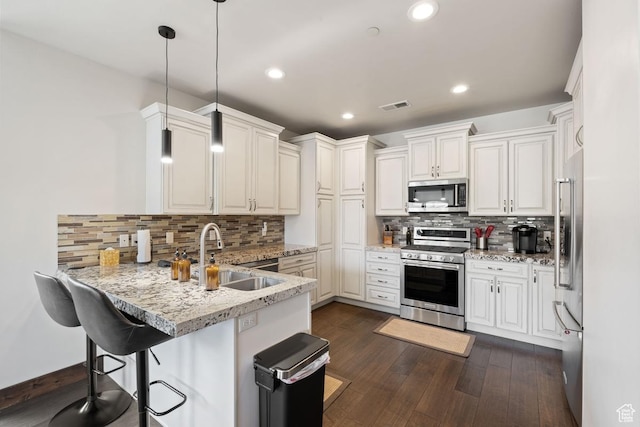 14311 N Buck Horn Trl Unit 42N, Kamas, UT 84036 - kitchen featuring stainless steel appliances, a peninsula, a sink, backsplash, and decorative light fixtures