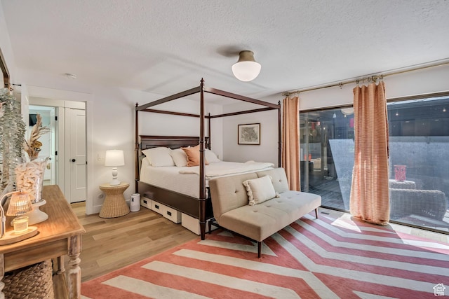 2634 S Cave Hollow Way, Bountiful, UT 84010 - bedroom with access to exterior, light wood-style floors, and a textured ceiling