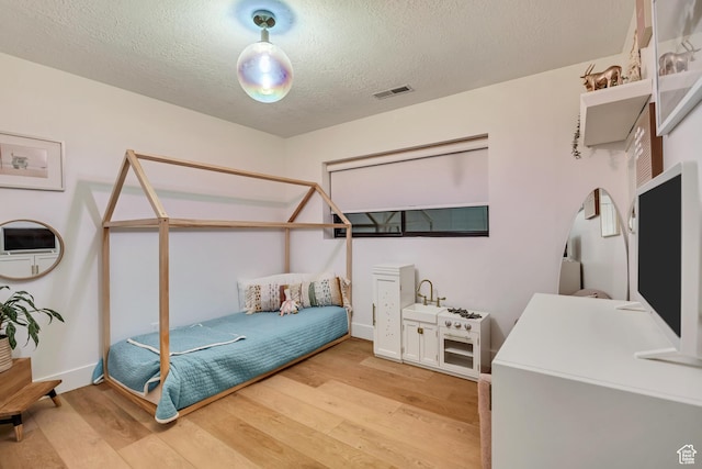 2634 S Cave Hollow Way, Bountiful, UT 84010 - bedroom featuring light wood finished floors, a textured ceiling, and baseboards