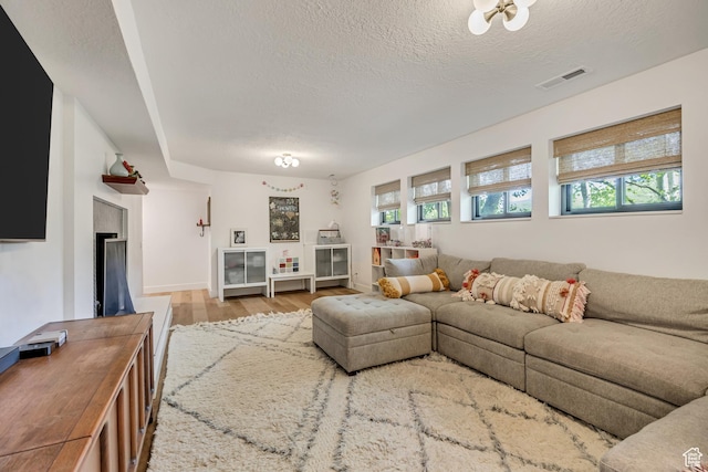 2634 S Cave Hollow Way, Bountiful, UT 84010 - living area featuring a textured ceiling, wood finished floors, baseboards, and a fireplace