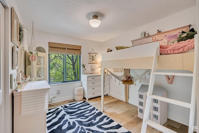 2634 S Cave Hollow Way, Bountiful, UT 84010 - bedroom with a textured ceiling, light wood-type flooring, and baseboards