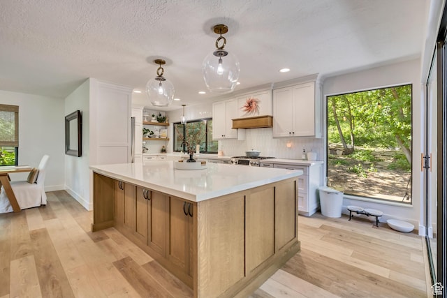 2634 S Cave Hollow Way, Bountiful, UT 84010 - kitchen featuring light countertops, range, a kitchen island, light wood-style floors, and recessed lighting