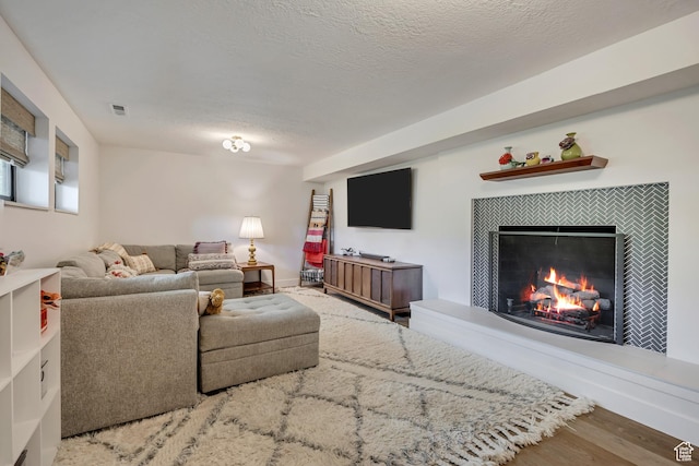 2634 S Cave Hollow Way, Bountiful, UT 84010 - living room featuring a tiled fireplace, wood finished floors, and a textured ceiling