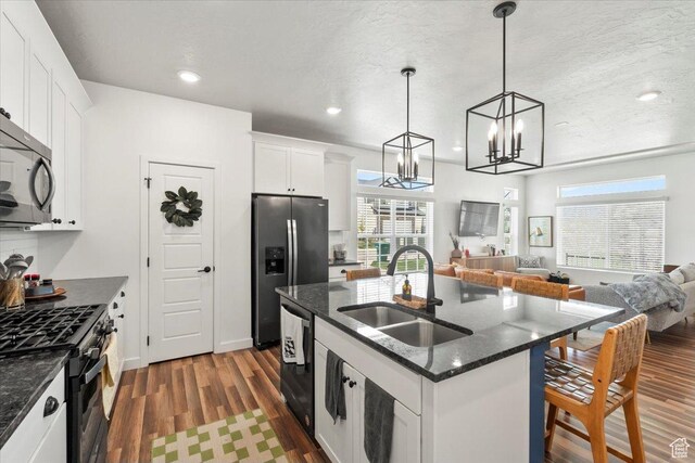 4376 W Bromwell Ct, Lehi, UT 84043 - kitchen with black appliances, a sink, wood finished floors, open floor plan, and a kitchen island with sink