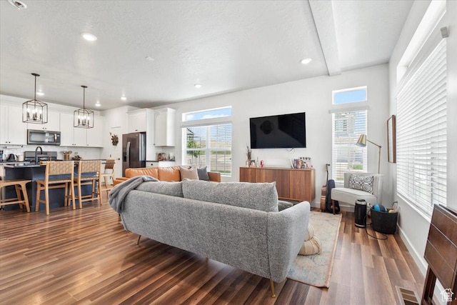 4376 W Bromwell Ct, Lehi, UT 84043 - living room featuring dark wood finished floors, plenty of natural light, recessed lighting, baseboards, and a chandelier
