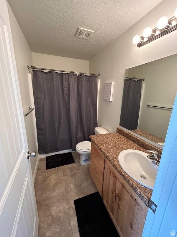 672 N 100 W, Vernal, UT 84078 - bathroom featuring vanity, a textured ceiling, and curtained shower