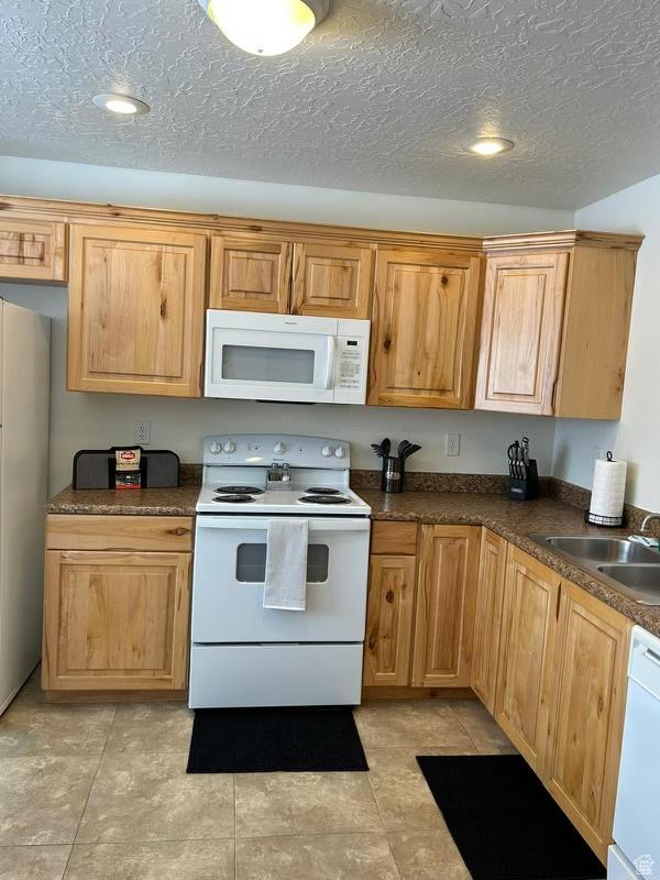 672 N 100 W, Vernal, UT 84078 - kitchen featuring white appliances, dark countertops, a textured ceiling, light tile patterned floors, and recessed lighting