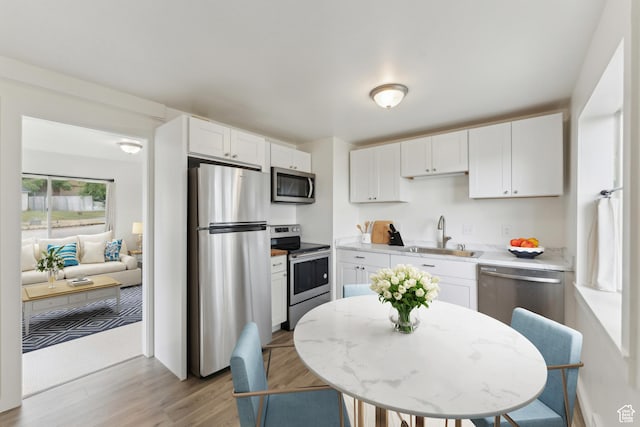15 Airlane Dr, Clearfield, UT 84015 - kitchen featuring stainless steel appliances, a sink, light wood-style floors, and white cabinets