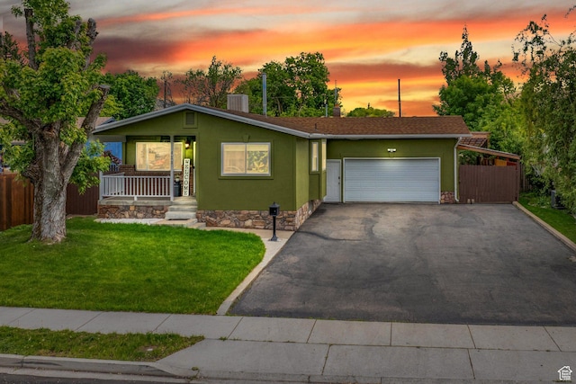 430 W 550 N, Logan, UT 84321 - view of front facade featuring covered porch, an attached garage, asphalt driveway, and stucco siding