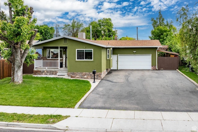 430 W 550 N, Logan, UT 84321 - view of front of house with covered porch, an attached garage, asphalt driveway, stucco siding, and central AC