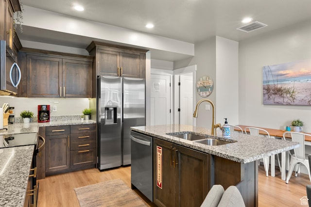 150 W Seasons Loop Unit 3, Garden City, UT 84028 - kitchen featuring a sink, appliances with stainless steel finishes, light wood finished floors, dark brown cabinetry, and light stone counters