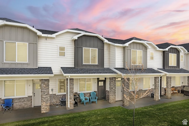 150 W Seasons Loop Unit 3, Garden City, UT 84028 - back of property at dusk featuring board and batten siding, stone siding, and covered porch