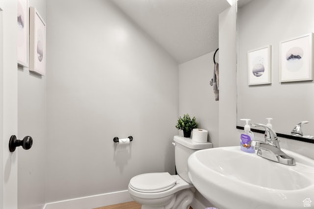 150 W Seasons Loop Unit 3, Garden City, UT 84028 - bathroom featuring a sink, toilet, vaulted ceiling, baseboards, and wood finished floors