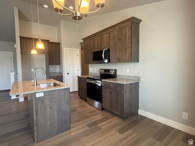 268 S 400 W, Tooele, UT 84074 - kitchen with stainless steel appliances, a sink, dark wood finished floors, light stone counters, and baseboards