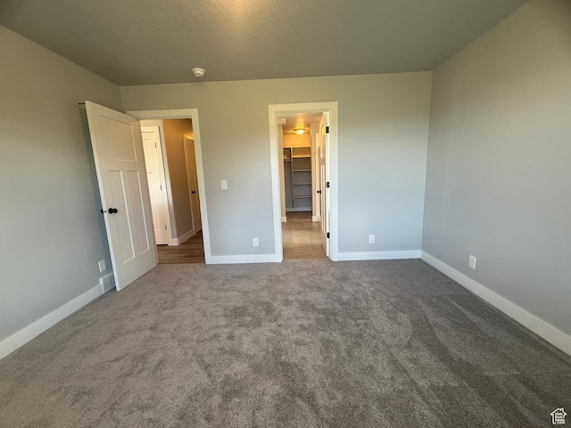 268 S 400 W, Tooele, UT 84074 - unfurnished bedroom featuring baseboards, carpet floors, and a walk in closet