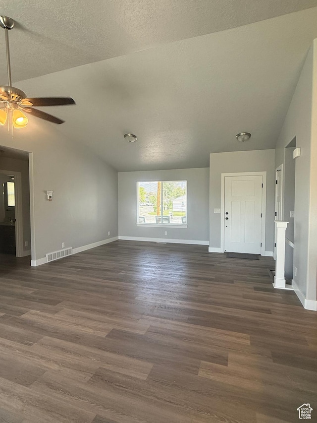 268 S 400 W, Tooele, UT 84074 - unfurnished living room featuring vaulted ceiling, baseboards, dark wood-style floors, ceiling fan, and a textured ceiling