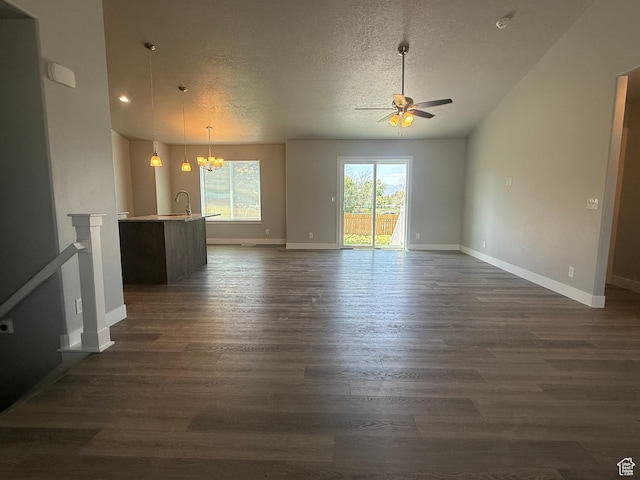 268 S 400 W, Tooele, UT 84074 - unfurnished living room with ceiling fan, a textured ceiling, dark wood finished floors, a chandelier, and baseboards