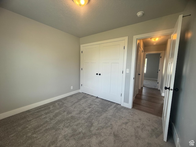 268 S 400 W, Tooele, UT 84074 - unfurnished bedroom with dark carpet, baseboards, a closet, and a textured ceiling