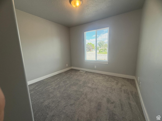 268 S 400 W, Tooele, UT 84074 - spare room featuring baseboards, dark colored carpet, and a textured ceiling