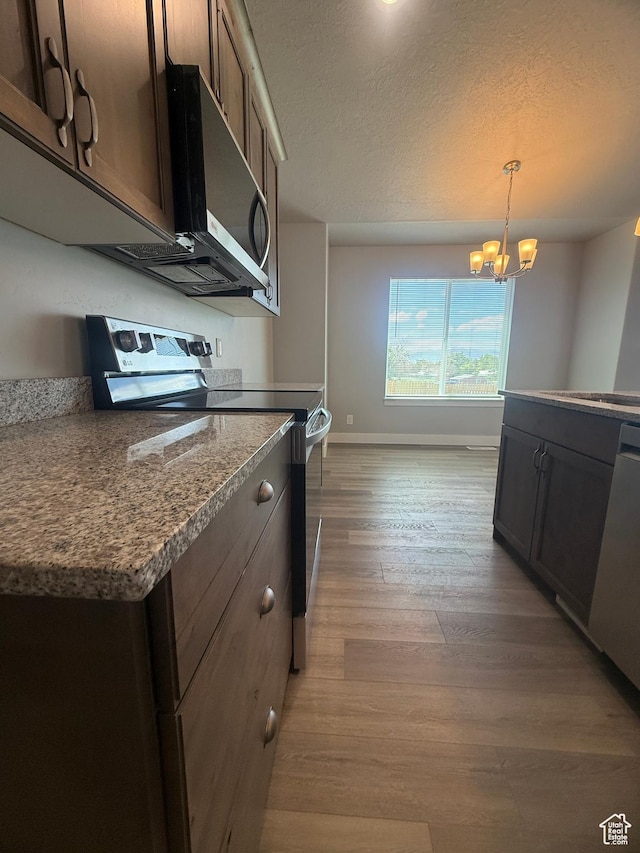268 S 400 W, Tooele, UT 84074 - kitchen featuring appliances with stainless steel finishes, light wood-style floors, baseboards, a textured ceiling, and a chandelier
