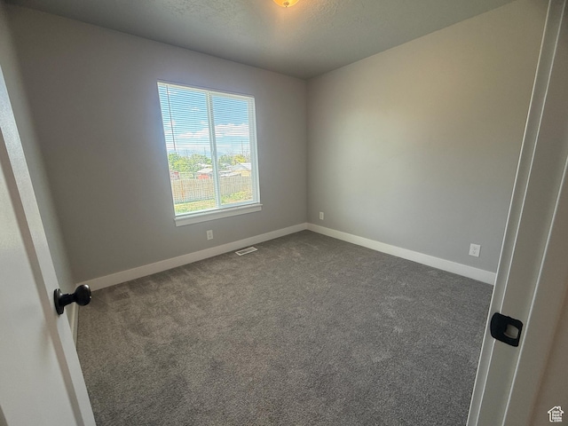 268 S 400 W, Tooele, UT 84074 - empty room featuring dark colored carpet, baseboards, and a textured ceiling