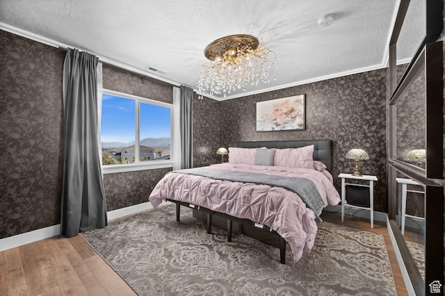 1067 W Ludington Ct, Bluffdale, UT 84065 - bedroom featuring wallpapered walls, wood finished floors, a textured ceiling, baseboards, and ornamental molding