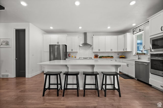 1067 W Ludington Ct, Bluffdale, UT 84065 - kitchen with stainless steel appliances, wall chimney exhaust hood, a sink, a center island, and backsplash