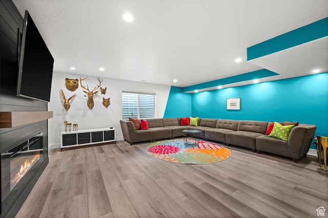 1067 W Ludington Ct, Bluffdale, UT 84065 - living room featuring wood finished floors, a glass covered fireplace, recessed lighting, and baseboards