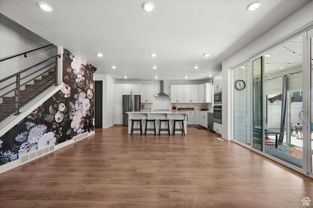 1067 W Ludington Ct, Bluffdale, UT 84065 - living area featuring wood finished floors, a textured ceiling, recessed lighting, stairs, and baseboards