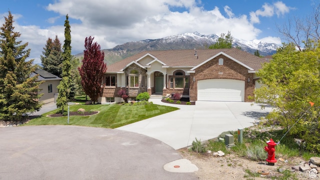 14825 S Meadow Oak Ct, Draper, UT 84020 - view of front of house featuring a mountain view, concrete driveway, a front lawn, brick siding, and an attached garage