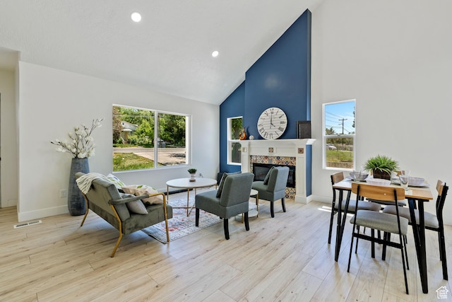905 N 100 E, Pleasant Grove, UT 84062 - living area with high vaulted ceiling, a glass covered fireplace, light wood-type flooring, baseboards, and recessed lighting
